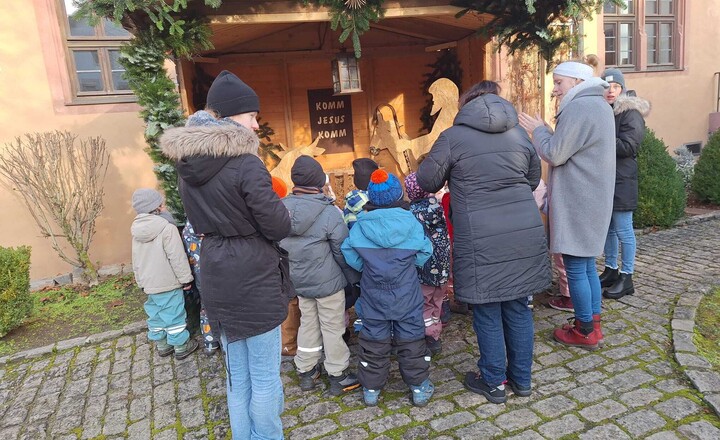 Bild mit betrachtenden Personen an der Krippe