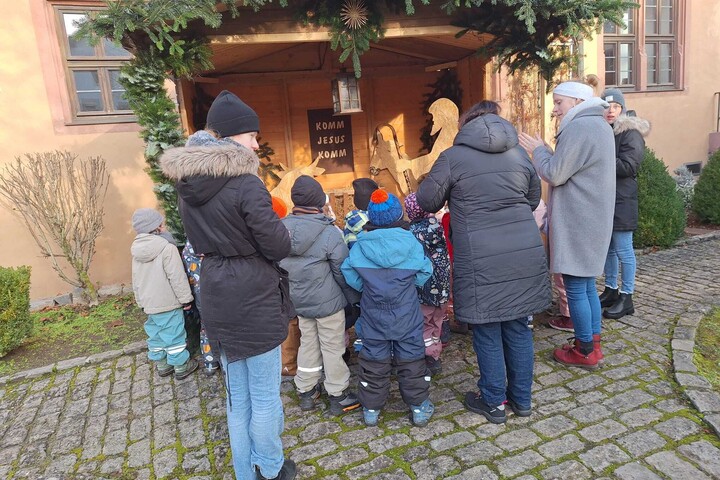 Bild mit betrachtenden Personen an der Krippe