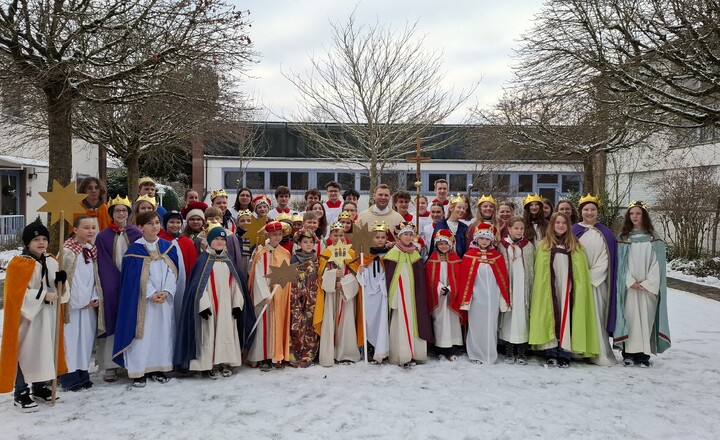 Sternsingergruppe mit Pfarrer im Innenhof der Kuratie
