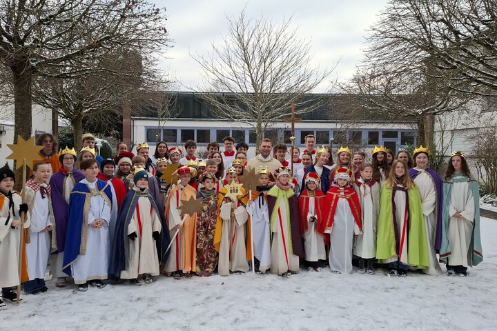 Sternsingergruppe mit Pfarrer im Innenhof der Kuratie